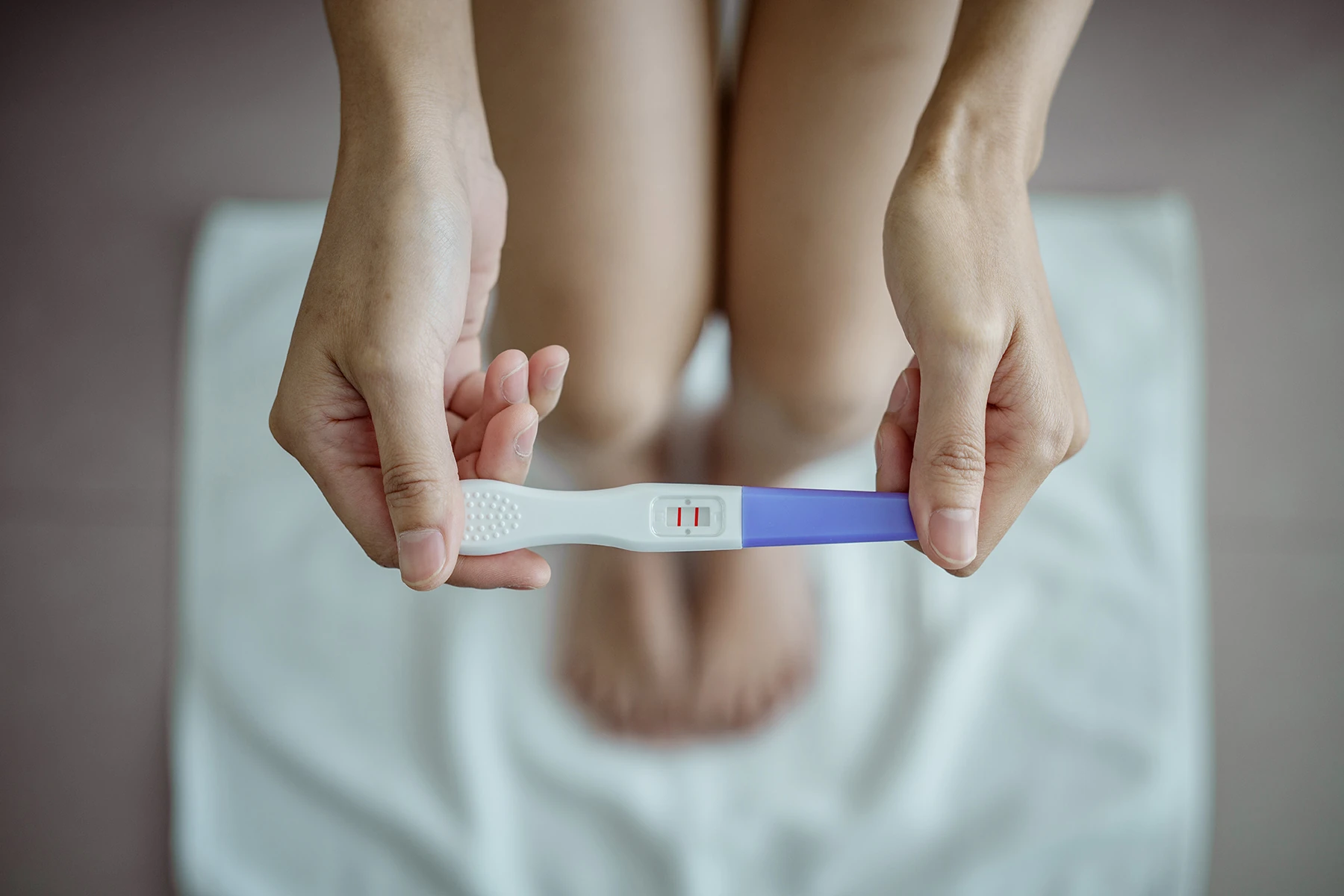 Close-up of young woman holds a pregnancy test in her hands. Positive pregnancy test